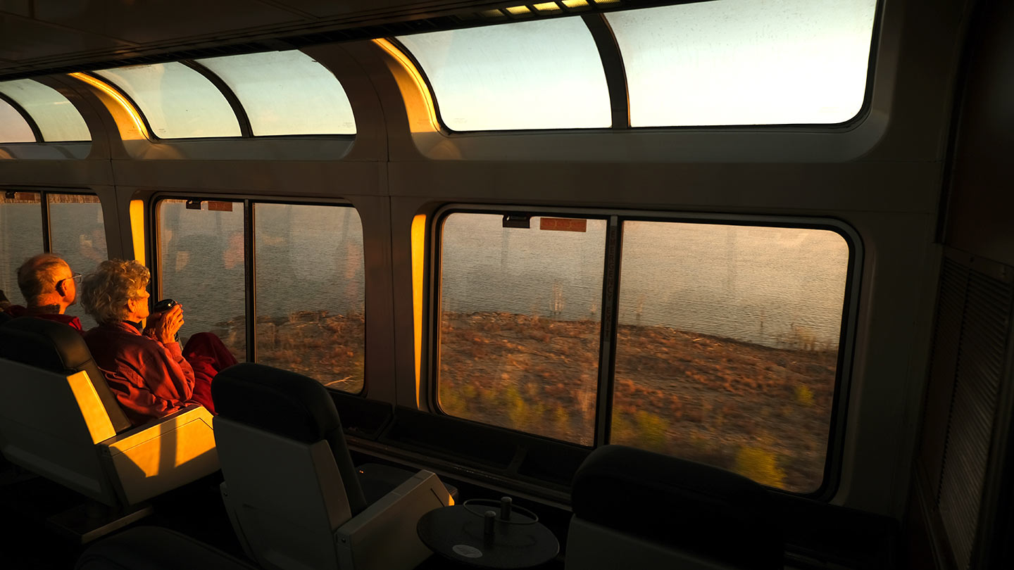 A couple watches the sun rise over Colorado in the observation car of the Southwest Chief.