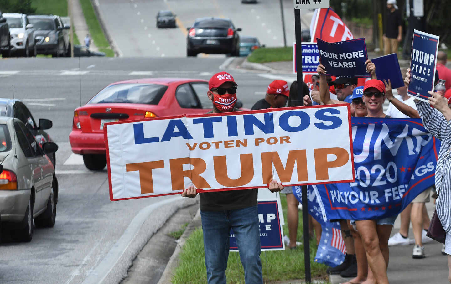People hold placards at a Latinos for Trump campaign rally at Central Christian University on October 10, 2020, in Orlando, Florida.