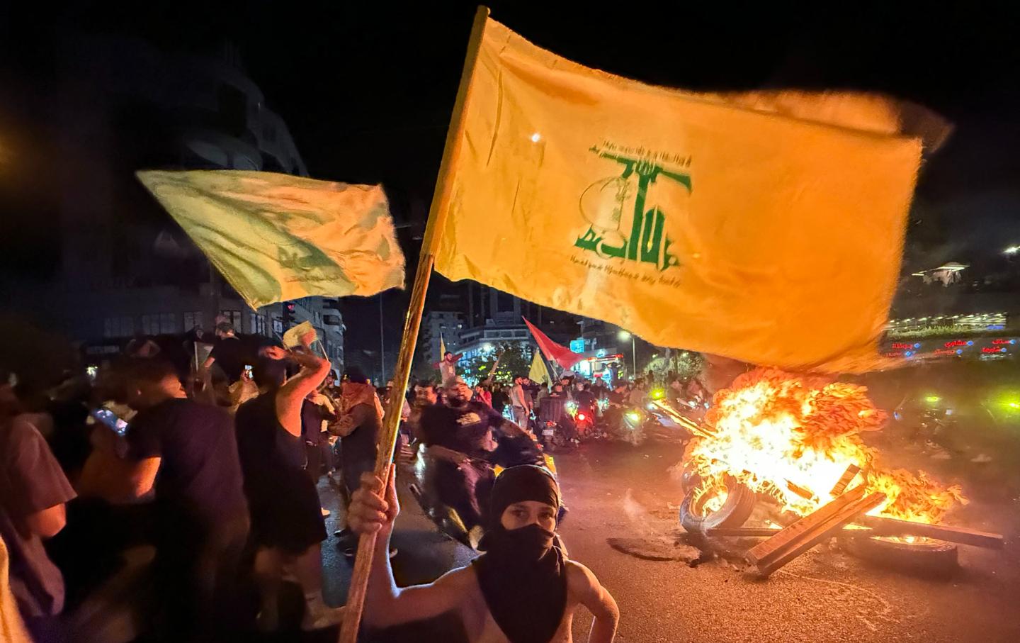 Supporters of Lebanon’s Hezbollah militant group block the streets with burning tires as they rally in cars and motorbikes to protest the government's endorsement of a plan to disarm it, in Beirut’s southern suburbs early on August 8, 2025.