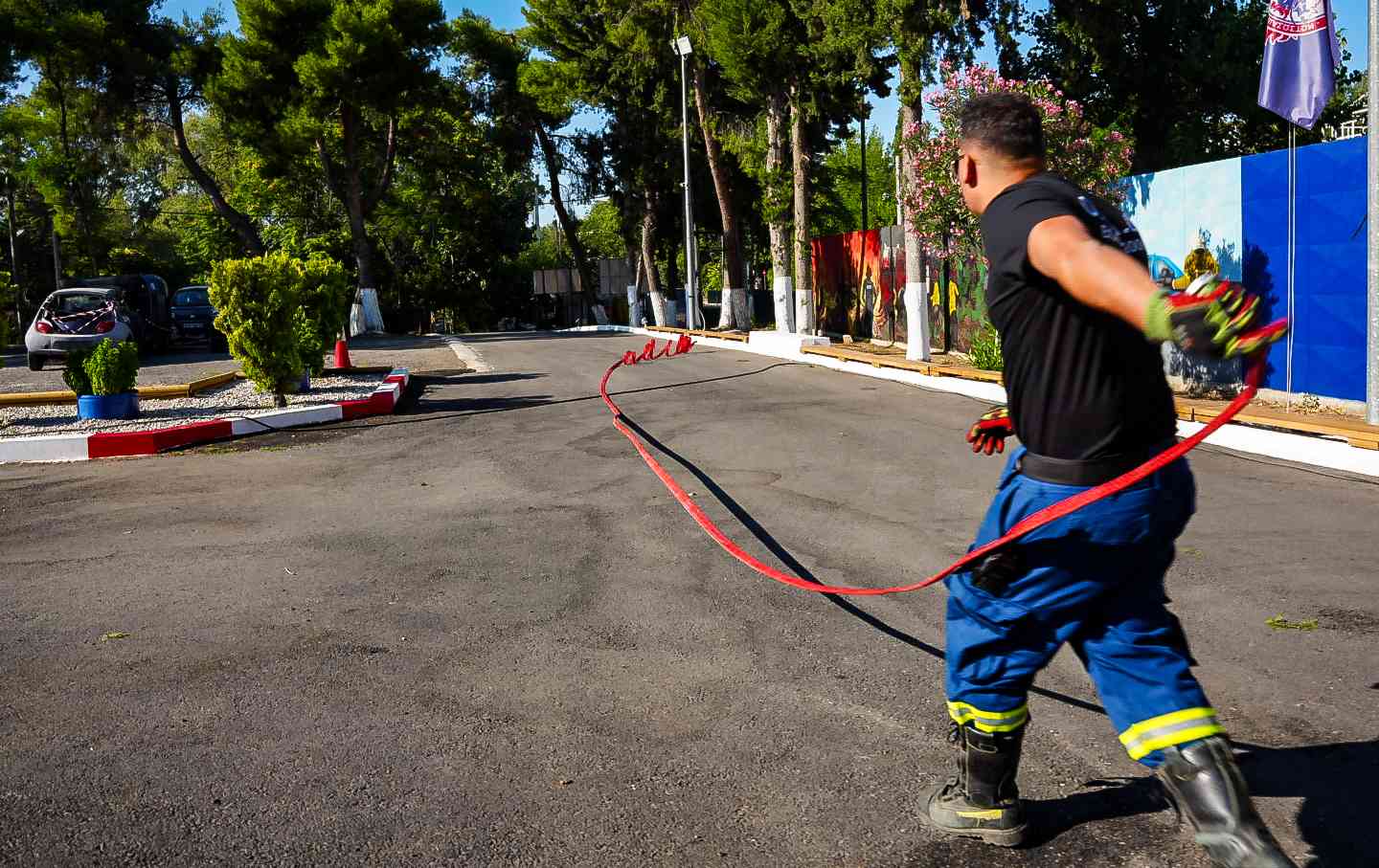 A volunteer in Greece unrolls a firehose in preparation for a wildfire.